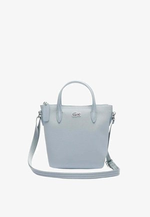 Sac à main Lacoste bleu clair avec double poignée, bandoulière ajustable et petit logo crocodile sur le devant.