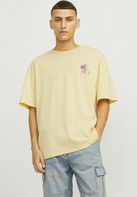 Geel katoenen T-shirt met een relaxte pasvorm, voorzien van een kleine geprinte afbeelding van een palmboom en een zon op de linkerborst.