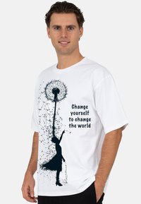 Witte katoenen t-shirt met een zwarte silhouet van een meisje dat een paardenbloem vasthoudt, met de tekst "Verander jezelf om de wereld te veranderen" weergegeven.