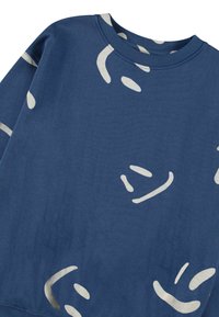 Μπλε φούτερ με απαλή υφή, κυκλικό λαιμόκοψη και αφηρημένα κρεμ σχέδια κατακερματισμένα πάνω στο ύφασμα.