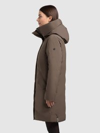 Duga smeđa pernata jakna s visokim ovratnikom i velikim kapuljačom. Ima bočne džepove i zatvaranje na patentni zatvarač, s glatkom, mat teksturom.