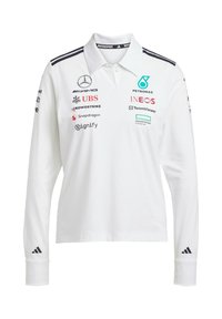 Vit långärmad polo med krage, med svarta ränder och flera sponsorlogotyper i olika färger på framsidan och ärmarna.