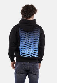 Felpa nera con un design grafico a gradiente blu sul retro, che presenta un motivo a onda. Realizzata in tessuto morbido e testurizzato.