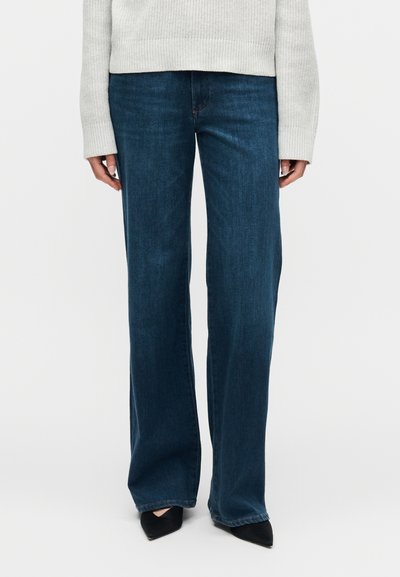 Τζιν παντελόνι σε σκούρο μπλε με φαρδιά μπατζάκια, κατασκευασμένο από ντένιμ, με κλασικό σχέδιο πέντε τσεπών και αντίθετη ραφή. Λειανή υφή, χωρίς διακοσμητικά.