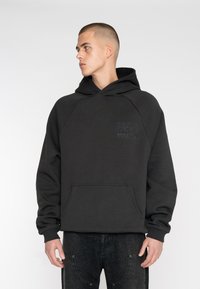 Black hooded sweatshirt in cotton blend, featuring a front kangaroo pocket, ribbed cuffs, and embossed logo detail on chest.