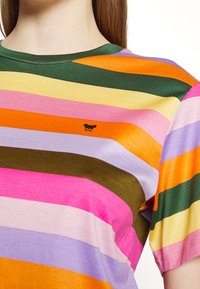 Gestreept T-shirt met korte mouwen in verschillende kleuren: roze, groen, oranje, geel en paars. Voorzien van een klein logo op het borstgebied.