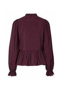 Burgundisk blus med krage, långa puffärmar och samlad peplumnederkant. Slät textur med subtil lyster och åtsittande manschetter.