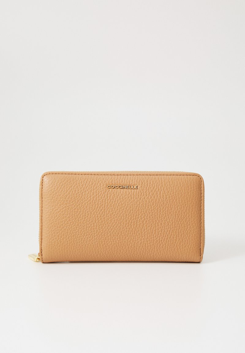 Portafoglio in pelle tan con finitura testurizzata, chiusura con zip e dettaglio del logo dorato sulla parte anteriore. Forma rettangolare e design minimalista.