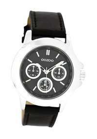 Montre chronographe noire avec boîtier en métal argenté, cadran noir avec trois sous-cadrans et bracelet en cuir noir.
