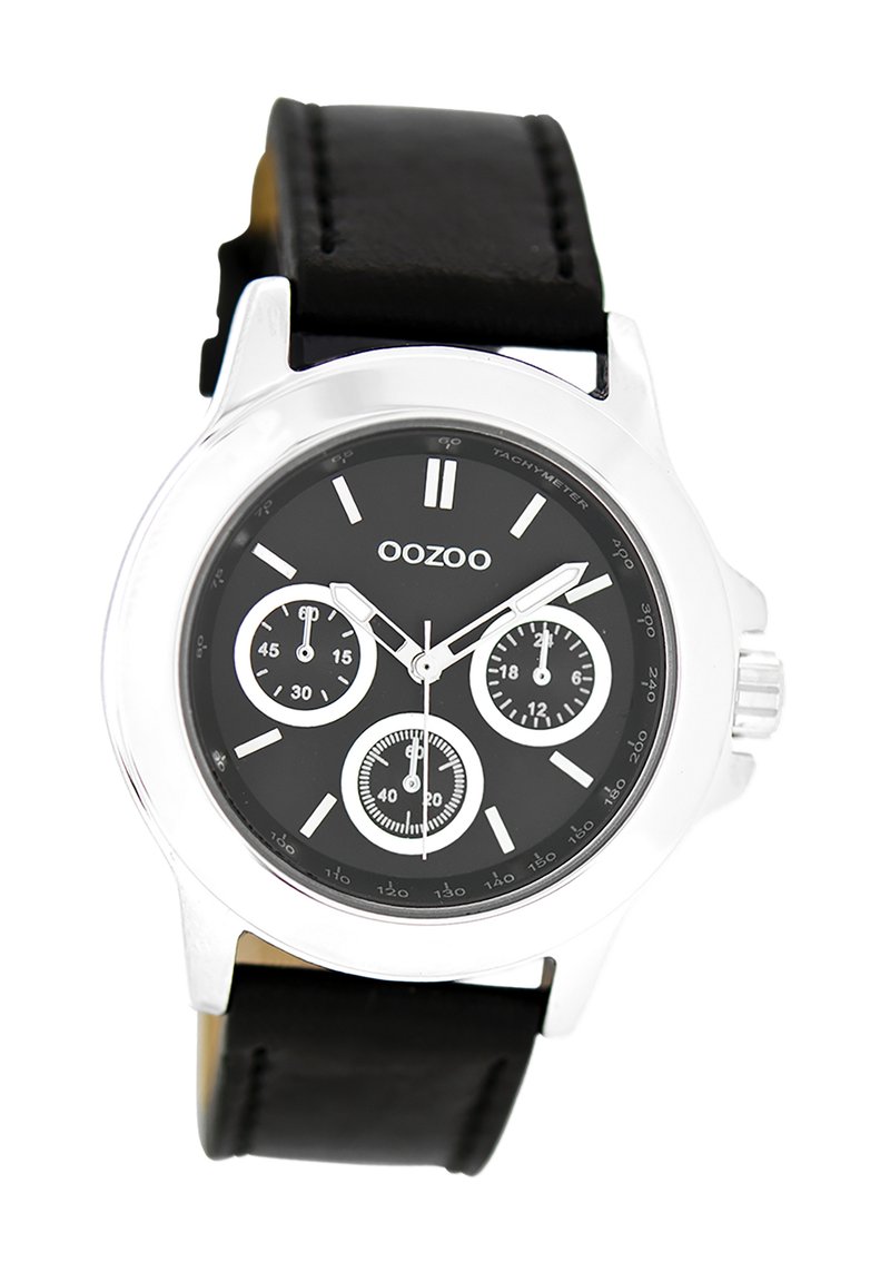 Montre chronographe noire avec boîtier en métal argenté, cadran noir avec trois sous-cadrans et bracelet en cuir noir.