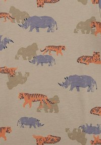 Musterstoff mit orangefarbenen und lila Tier-Silhouetten, darunter Tiger und Nashörner, auf einem hellbeigen Hintergrund.