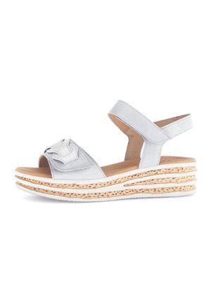 Sandalía gris claro con diseño de punta abierta, que presenta un acento floral en la correa y una suela de cuña texturizada con acabado de corcho natural.