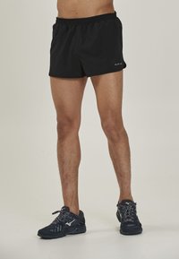 Sorte atletiske shorts med elastisk talje, lavet af let materiale, med et enkelt design uden synlige mønstre eller detaljer.