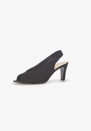 Zwarte suède slingback peeptoe pumps met een middelhoge naaldhak en elastische bandjes op een witte achtergrond.