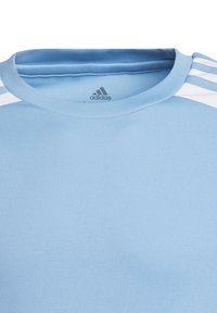 Světlomodré sportovní tričko s kulatým výstřihem, krátkými rukávy a třemi bílými pruhy na ramenech. Vyrobené z hladkého, prodyšného materiálu.