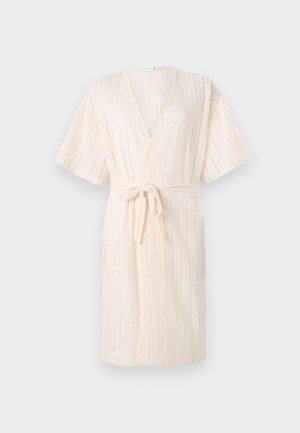 Lys beige kimono-stil badekåpe med knyt i midjen, med en teksturert chevron-mønster og korte ermer, laget av pustende stoff.