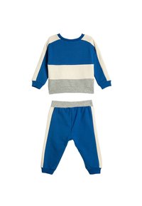 Blauwe en witte kleurgeblokte sweatshirt met lange mouwen en een grijze accent, gecombineerd met blauwe broeken met witte zijstrepen en een elastische tailleband.