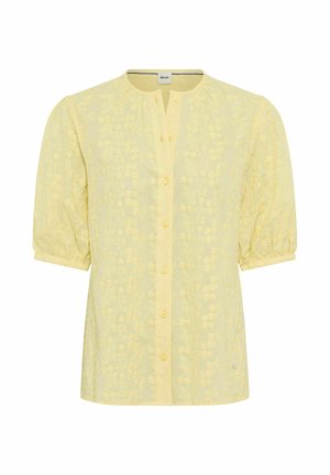 Blusa gialla a maniche corte con ricamo floreale, scollo tondo con patta frontale con bottoni e maniche leggermente gonfie che terminano con polsini elasticizzati.