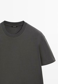 Anthrazitgraues T-Shirt mit Rundhalsausschnitt und kurzen Ärmeln, mit einem gerippten Kragen und einem Markenlabel im Nacken innen.