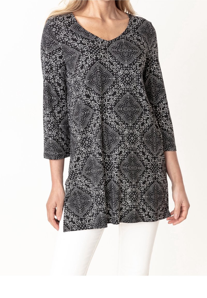 Svart tunika med V-ringning och trekvartsärmar, med ett vitt geometriskt mönster och en lös, flödande passform.
