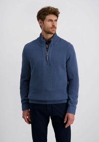 Blauer gestrickter Pullover mit einem halben Reißverschluss-Kragen, strukturiertem Muster, einfarbigen Rippbündchen und Saum, kombiniert mit einem gemusterten Hemd darunter.
