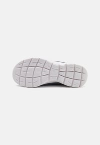 Semelle de chaussure de sport avec une base en caoutchouc blanc texturé et un motif en grille pour une adhérence optimale. Transition en douceur vers un dessus navy en matériau respirant.