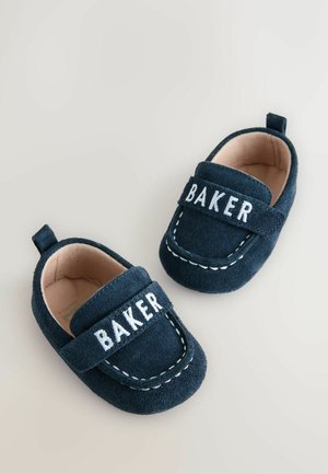Marineblaue Wildleder-Babyschuhe mit einem Riemen, weißem "BAKER"-Schriftzug, kontrastierendem weißen Ziernähte und einem weichen Innenfutter.