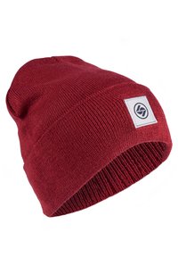 Rote gestrickte Mütze mit umgeschlagenem Rand, auf der Seite mit einem weißen Etikett und einem schwarzen Logo. Hergestellt aus weichem, strukturiertem Material.