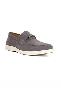 Gray suede loafers with white rubber sole, featuring a leather strap and metallic accent. Rounded toe and smooth texture.