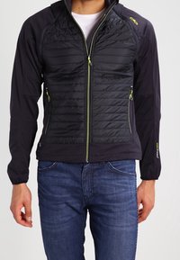 Sort isoleret jakke med polstret front, lange ærmer og hætte. Har gule lynlåse og logo-detaljer, tekstureret stof og en tætsiddende pasform.