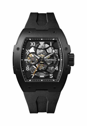Black automatic watch with a skeleton dial, featuring luminescent hour markers, a black rubber strap, and stainless steel accents.