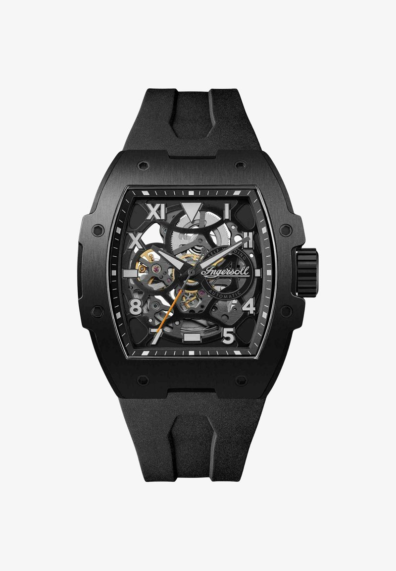 Montre automatique noire avec un cadran squelette, arborant des index luminescents, un bracelet en caoutchouc noir et des accents en acier inoxydable.