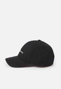 Sort baseball cap lavet af bomuld, med en buet skygge, broderet logo på forsiden og små farvede detaljer på siden.