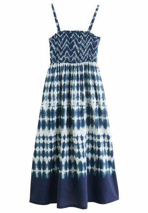 Maxi haljina ima smućeni korzet, tanke naramenice i bijelo-plavi tie-dye uzorak s lepršavom suknjom. Materijal se čini laganim i prozračnim.