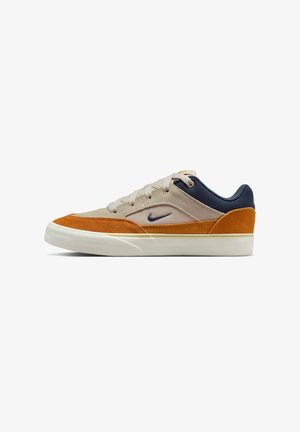 Baskets basses en beige, suède orange et tissu bleu marine avec une semelle blanche et un swoosh Nike bleu marine sur le côté.
