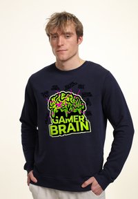 Felpa marina con una grafica vibrante di un cervello verde e rosa accompagnata dal testo "GAMER BRAIN", che mette in evidenza frasi legate ai videogiocatori. Tessuto morbido, maniche lunghe.