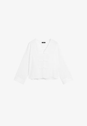 Hvid cropped bluse med lange ærmer, V-hals og dekorative knaplukninger foran. Glat tekstur og afslappet pasform.