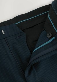 Marineblau gestreifte Hose mit glatter Textur. Verfügt über einen Reißverschluss, einen Knopfverschluss und kontrastierende türkisfarbene Akzente am Bund.