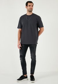 Tmavě šedé tričko z měkkého materiálu, krátké rukávy, volný střih. V kombinaci s distressed černými skinny džíny a černými teniskami. Doplňeno stříbrným řetízkem.