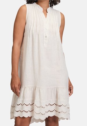 Robe blanche en lin sans manches avec des boutons sur le devant, des plis verticaux sur la poitrine et un détail d'ourlet en dentelle à œillets festonnée.