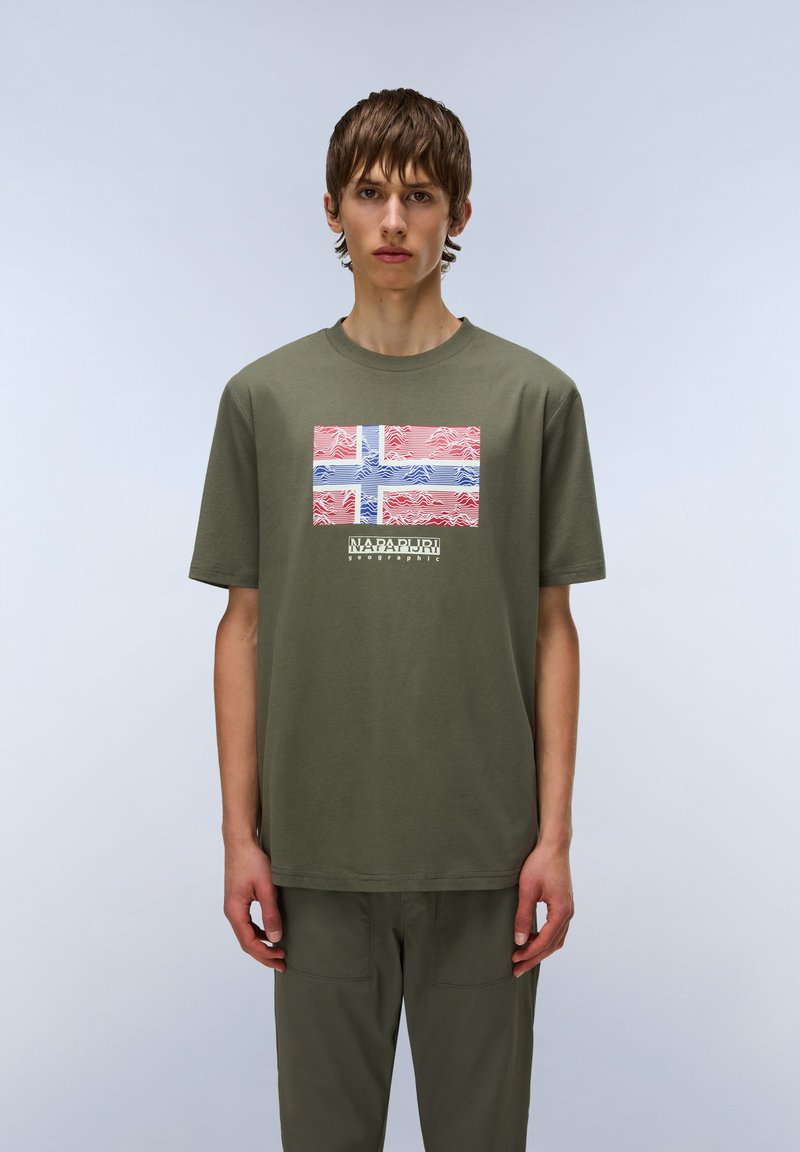 Olivgrünes Baumwoll-T-Shirt mit einem bedruckten roten und blauen abstrakten Design, das der norwegischen Flagge ähnelt, und fett gedrucktem Text darunter.