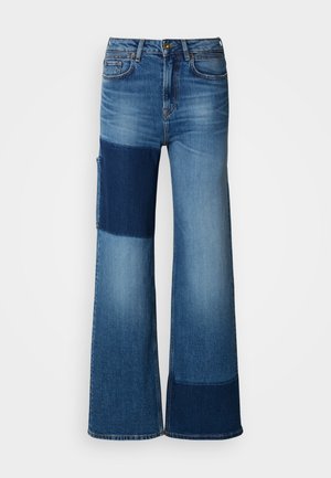 Vide jeans laget av blå denim, med et lappeteppe-design i ulike blå nyanser, synlige sømmer og en tradisjonell midjebånd.
