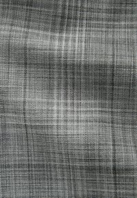 Karirani tekstil s crno-sivom paletom boja, s tkanim uzorkom i glatkom teksturom. Lagano sjajna površina.