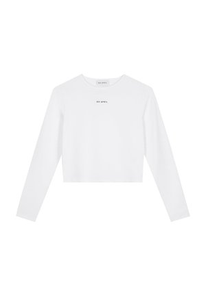 Hvit langermet crop top laget av glatt stoff, har rund hals og en liten svart trykt logo på brystet.