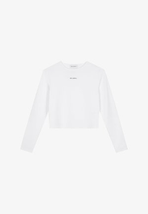 Fehér, hosszú ujjú crop top sima anyagból, lekerekített nyakkal és egy kisebb fekete logónyomattal a mellkason.