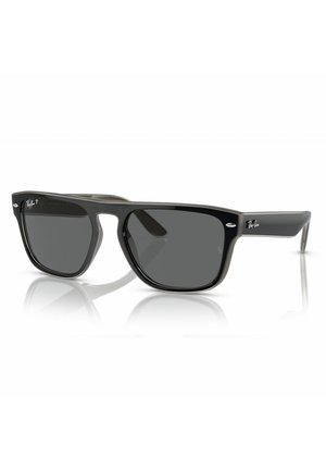 Occhiali da sole in plastica nera con lenti quadrate, tonalità grigio scuro e logo Ray-Ban sulle stanghette. Presentano una montatura spessa e un design angolare.