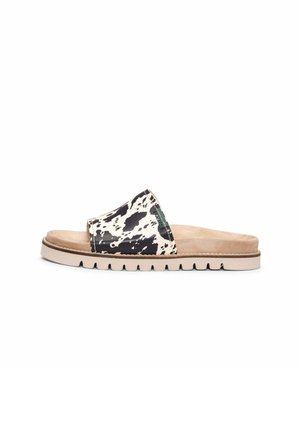 Sandalia tipo slip-on con suela beige y plantilla acolchada, con una tira con estampado de vaca en blanco y negro en la parte superior.