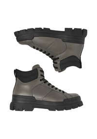 Pelēki augsti ādas zābaki ar melnu gumijas zolīti, šņoru aizdari un polsterētu potīšu atbalstu. Uz zolītes izteikti raksturīgi teksturēti raksti.