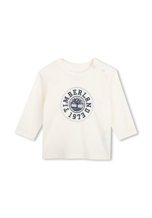 T-shirt bébé blanc à manches longues avec col rond, deux boutons aux épaules et logo Timberland 1973 bleu marine sur le devant.
