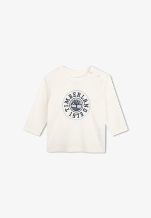 T-shirt bébé blanc à manches longues avec col rond, deux boutons aux épaules et logo Timberland 1973 bleu marine sur le devant.